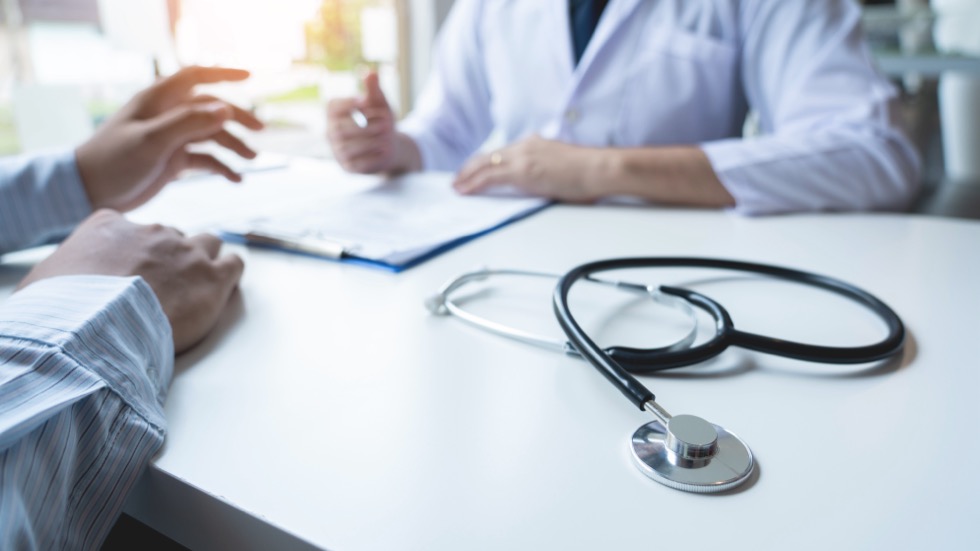 Focus on stethoscope and background doctor checkup on patient a diagnosis, health medical concept on desk in hospital or clinic.