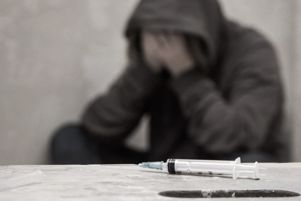 heroin addict next to syringe