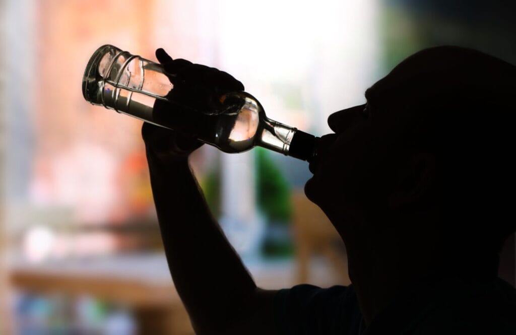 alcoholic man drinking in the dark